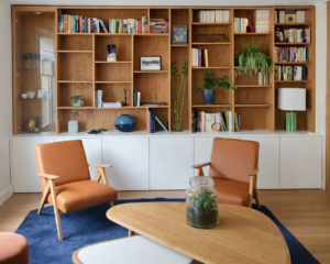 Bibliothèque sur mesure en bois dans un salon à Paris, aménagement intérieur chaleureux avec rangements intégrés